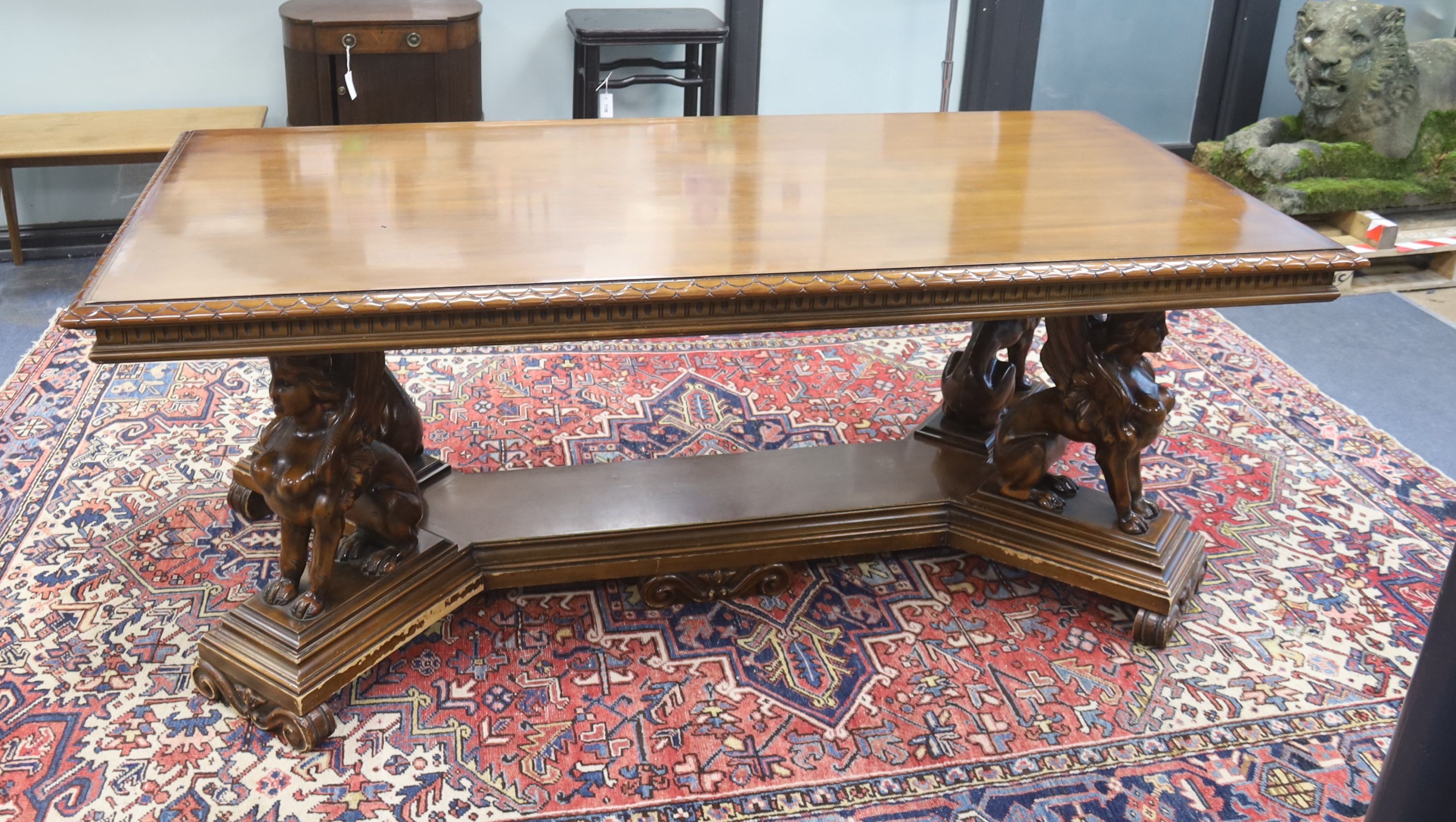 An Italian design rectangular walnut centre table with winged sphinx supports, width 196cm, depth 96cm, height 77cm